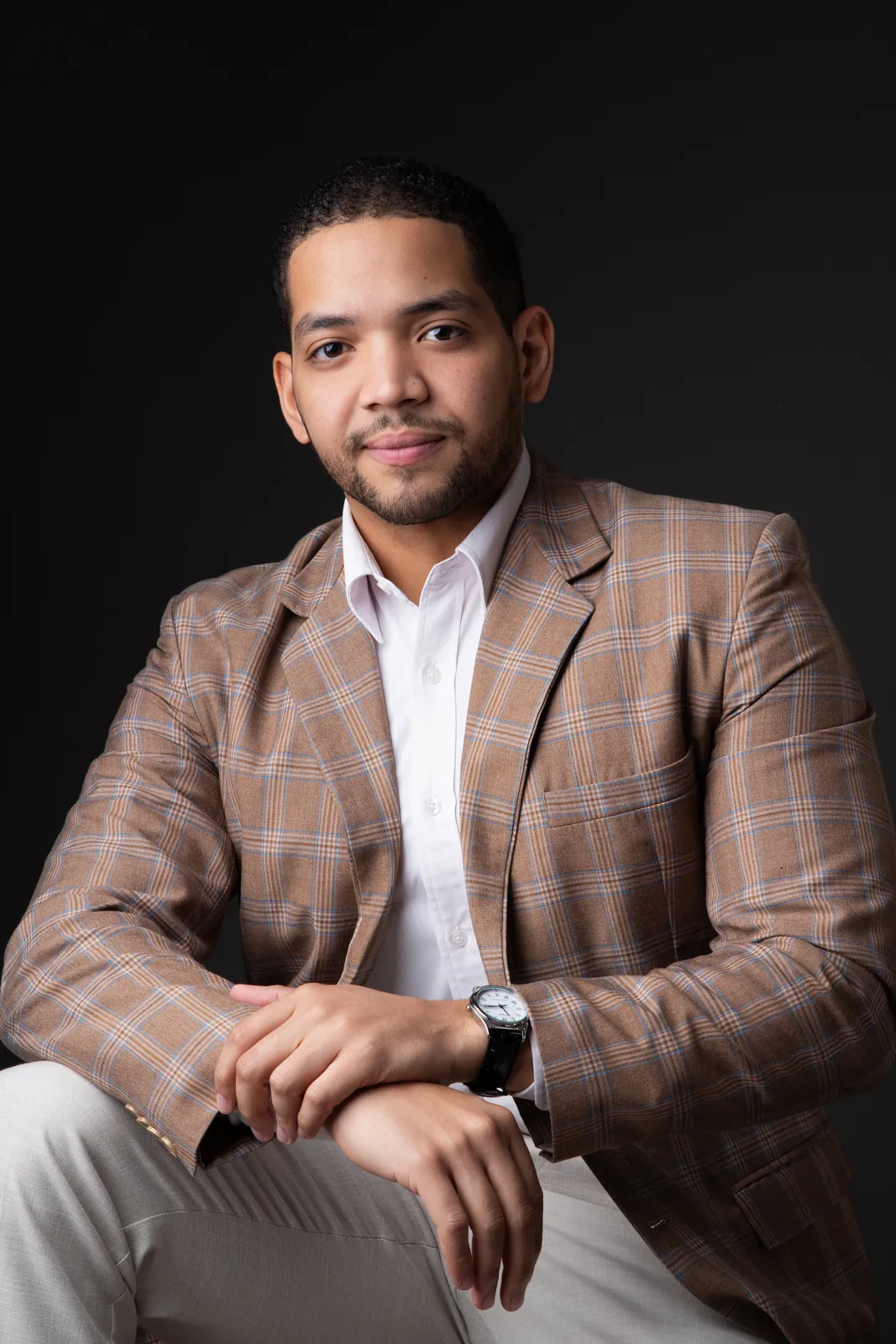 Retrato executivo de homem com blazer xadrez sobre fundo preto