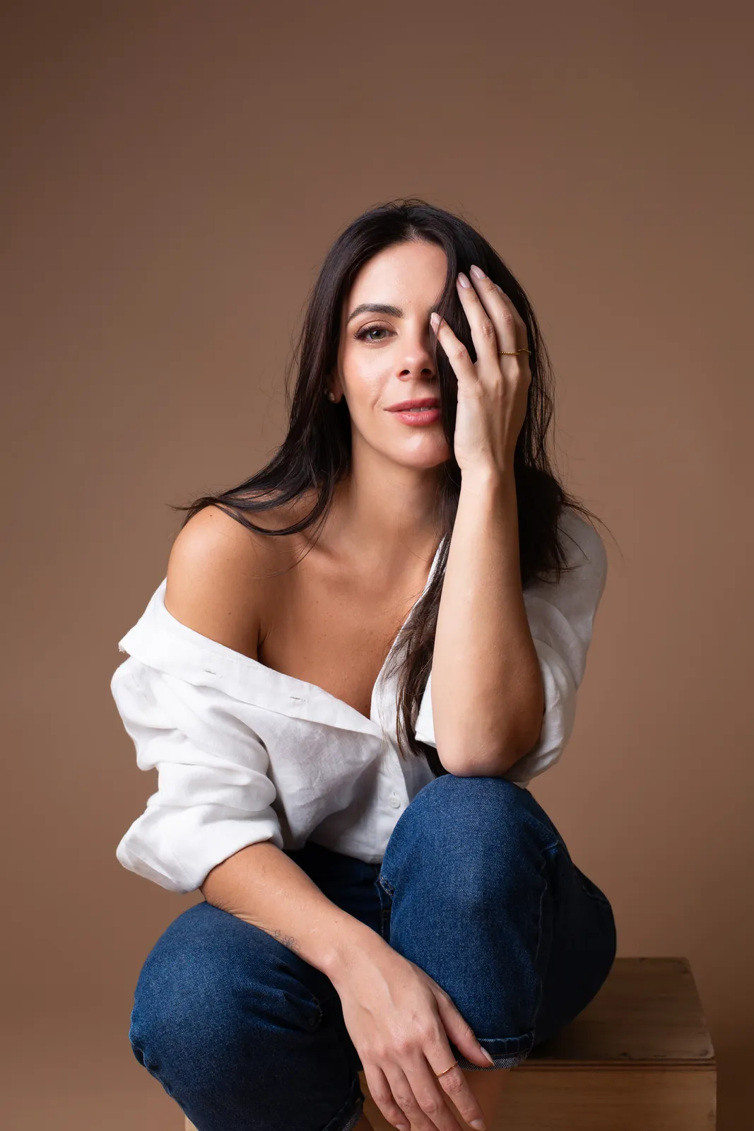 Retrato profissional de mulher com camisa branca e jeans