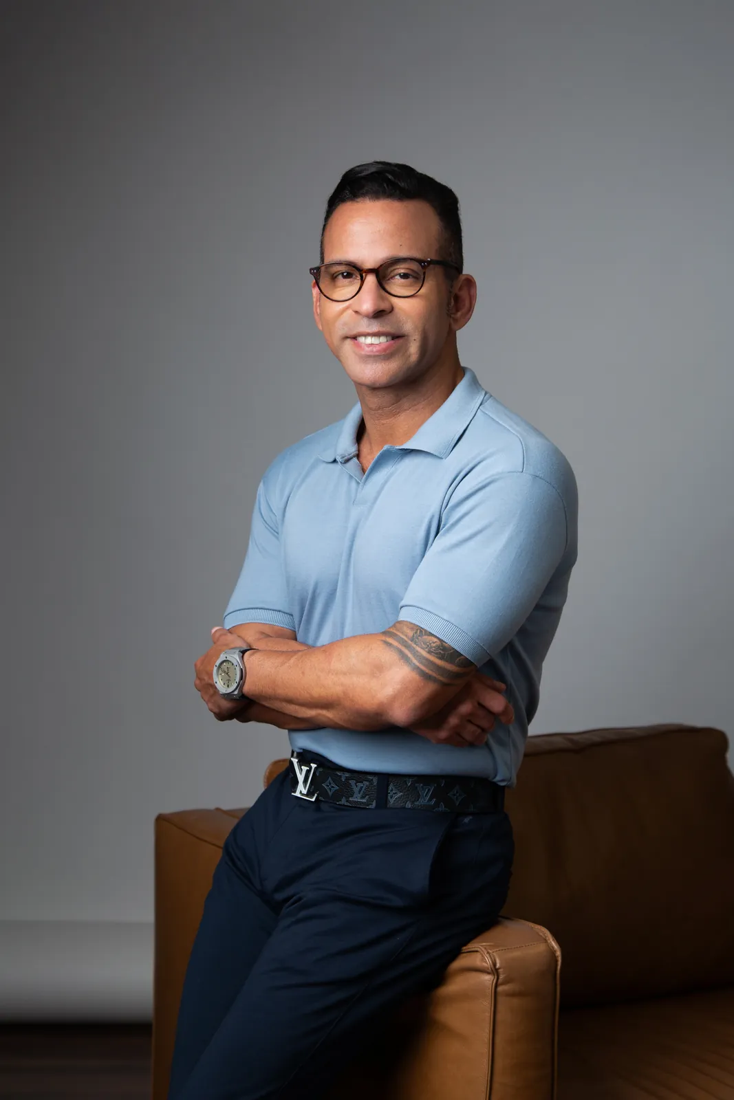 Retrato corporativo de homem com camisa polo azul e braços cruzados