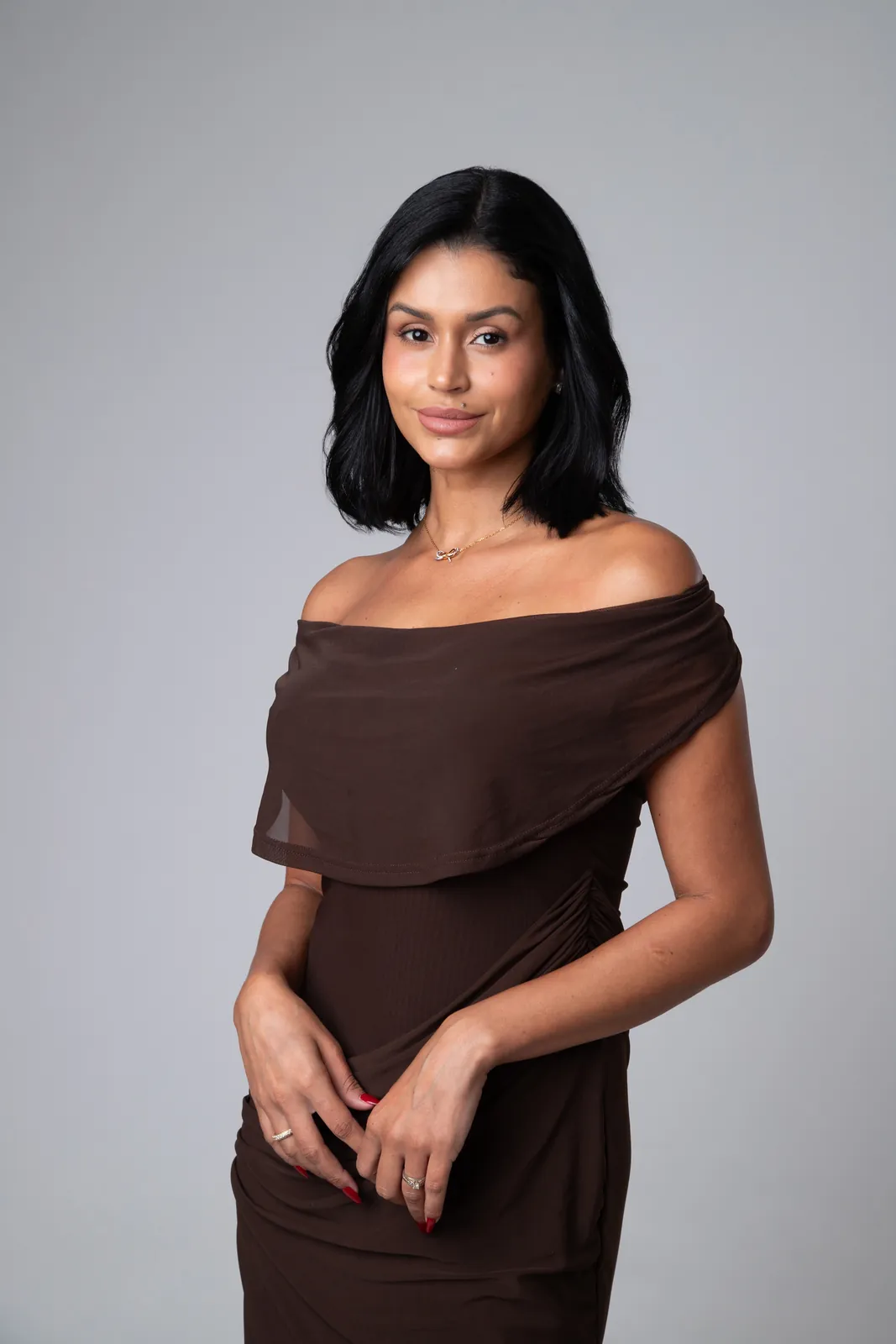 Retrato profissional de mulher com vestido marrom sobre fundo cinza